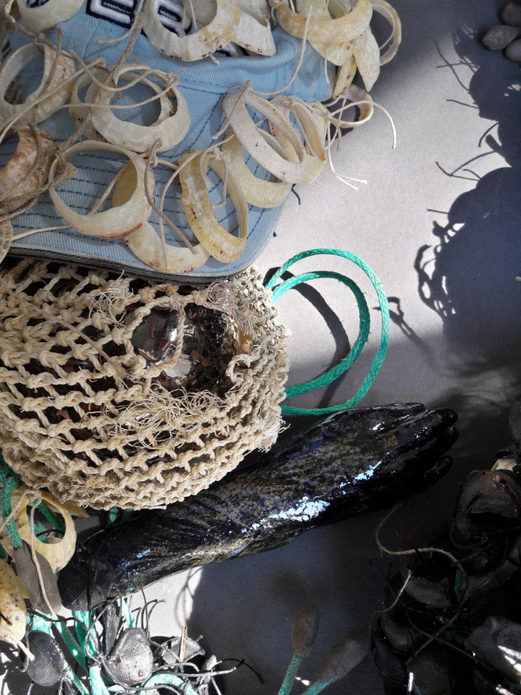 Casquette et filet de pêche, coquillage, écailles de grès noir, visage en céramique, algues séchées, fils de lin.  hauteur : 185cm x largeur 28cm x profondeur 20cm